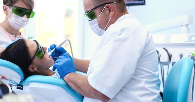 Стоматолог, работающий над зубами своих пациентов