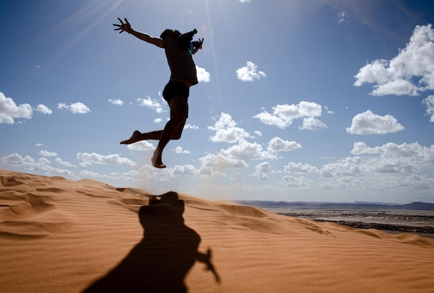 Man in the desert happy and jumps jumping in the desert celebrating her freedom