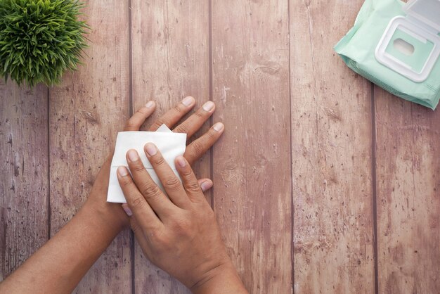 Man desinfecteert zijn handen met een nat doekje