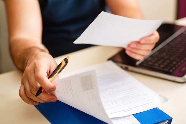 Man at a Desk with documents works online