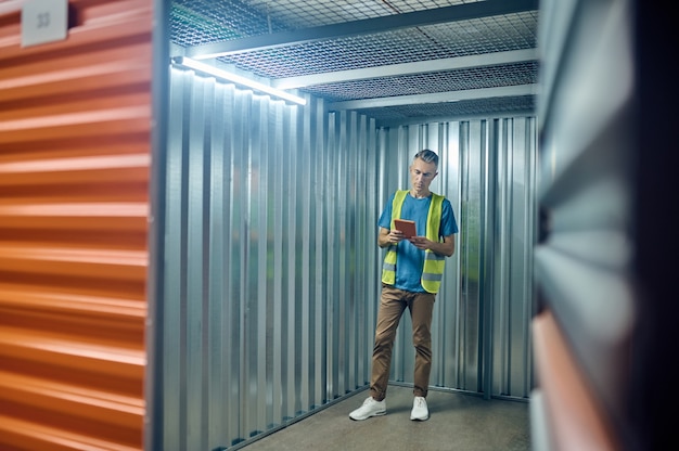 Foto man die aandachtig naar werktablet in garage kijkt