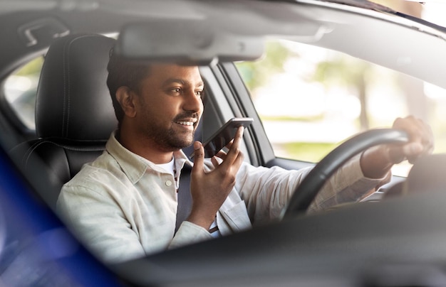 man die auto rijdt en stem opneemt met een smartphone