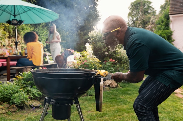 Man die barbecue zijaanzicht maakt