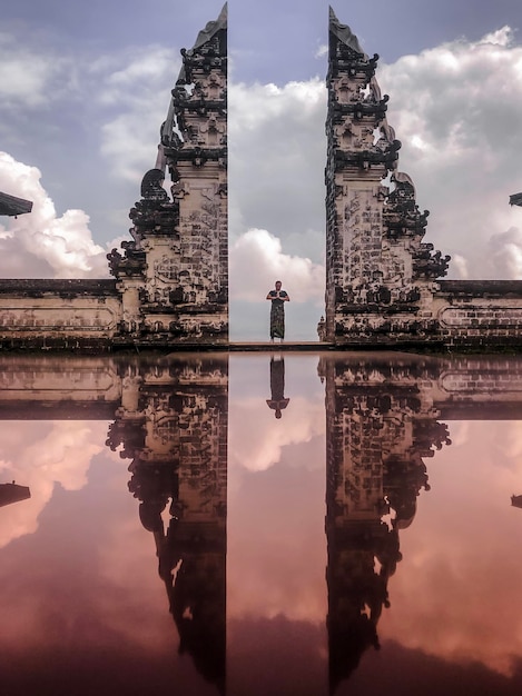 Foto man die bij de ingang van de tempel staat en tegen de hemel kijkt