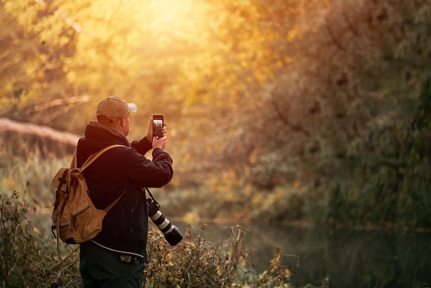 Man die buiten foto's maakt Profotograaf die landschaps- en natuurfoto's maakt Grote camera