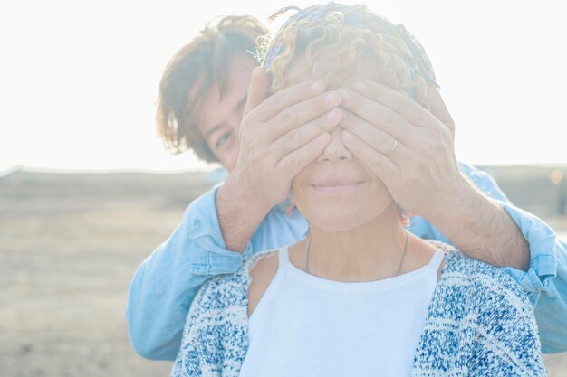 Foto man die de ogen van een vrouw bedekt.