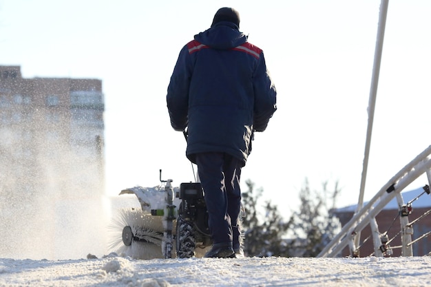 Man die de straat schoonmaakt van sneeuw handmatige tractor speciaal