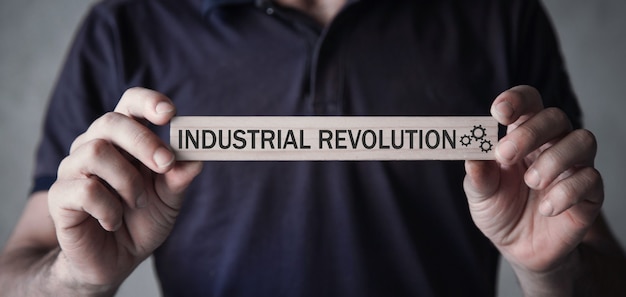 Man die de tekst van de industriële revolutie op houten blok toont.
