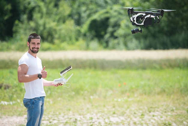 Man die drone bestuurt, vliegt of zweeft met afstandsbediening in de natuur