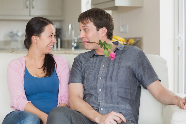 Man die een bloem presenteert aan de vrouw in zijn tanden