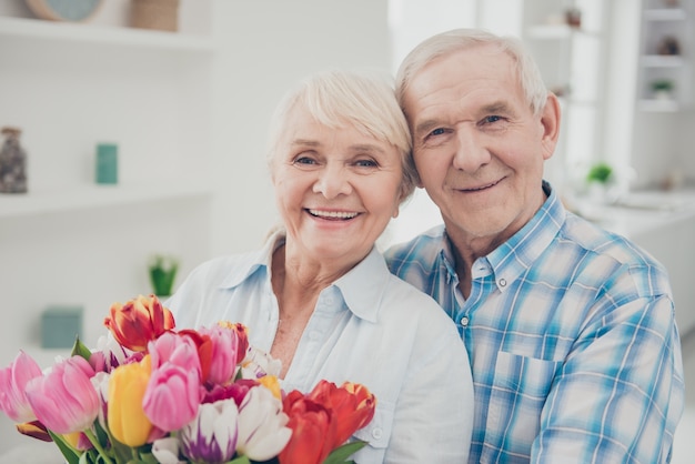 Man die een boeket bloemen geeft aan zijn vrouw