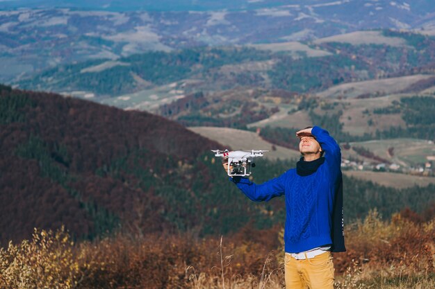 Foto man die een drone voor luchtfotografie houdt. silhouet tegen de zonsondergang hemel