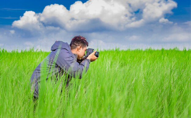 Man die een foto maakt met de camera in het veld Fotograaf in het veld die een foto maakt