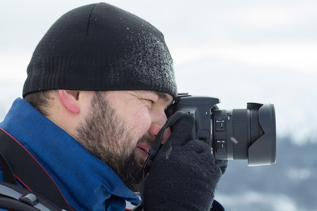 Man die een foto met zijn camera in de winter.