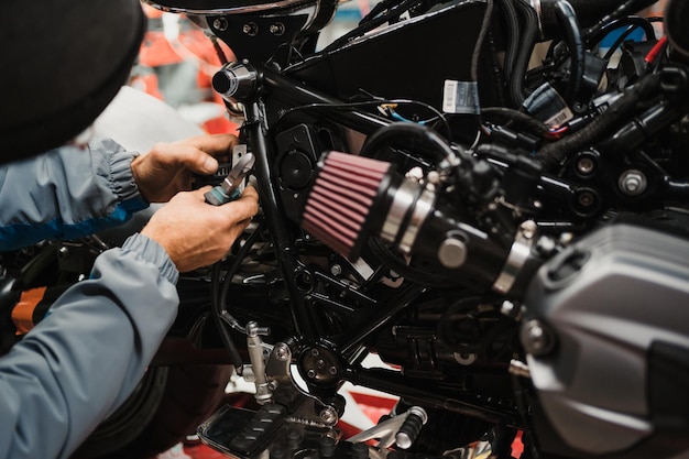 Man die een motorfiets repareert in een moderne werkplaats