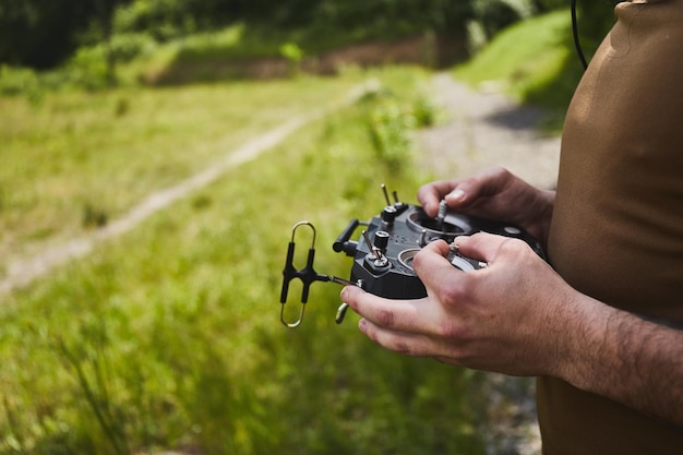 Man die een race-drone met hoge snelheid bestuurt met een quadcopter-drone op afstand met afstandsbediening