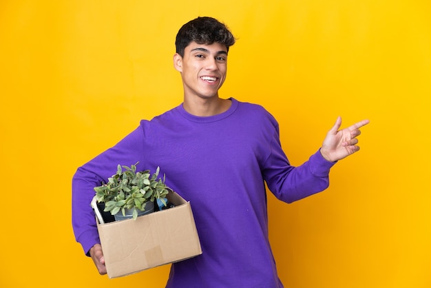 Man die een zet doet terwijl hij een doos vol dingen oppakt die de vinger naar de zijkant wijzen en een product presenteert