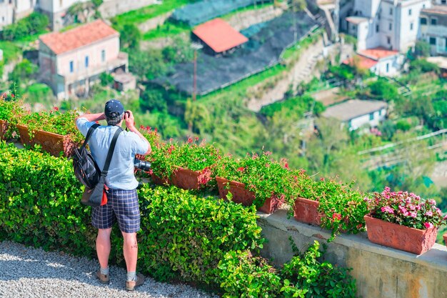 Man die foto's maakt met camera op het terras in het dorp ravello, tyrreense zee, amalfikust, italië