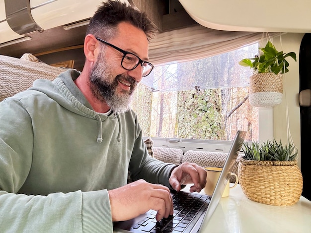 Man die in een camper werkt in een moderne online baan bedrijf Remote worker content creator influencer vanlife lifestyle concept mensen Moderne volwassen man die computer gebruikt in indoor vrijetijdsactiviteiten