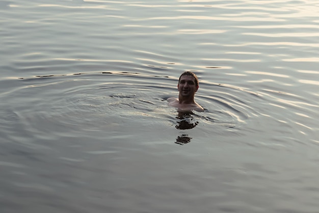 Man die in het hoofd van het meer zwemt en uit het water gluurt