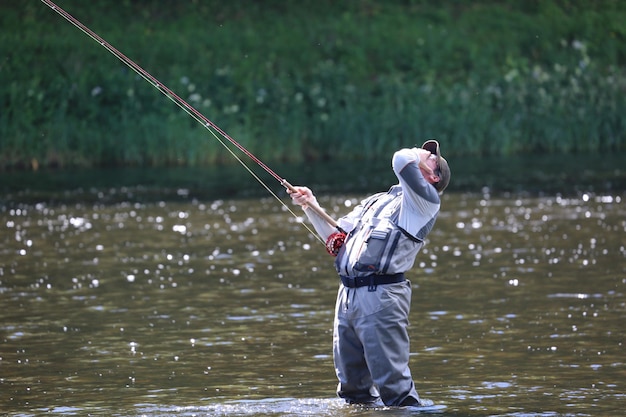 Man die in het water vissen