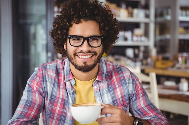 man die lacht terwijl het hebben van koffie