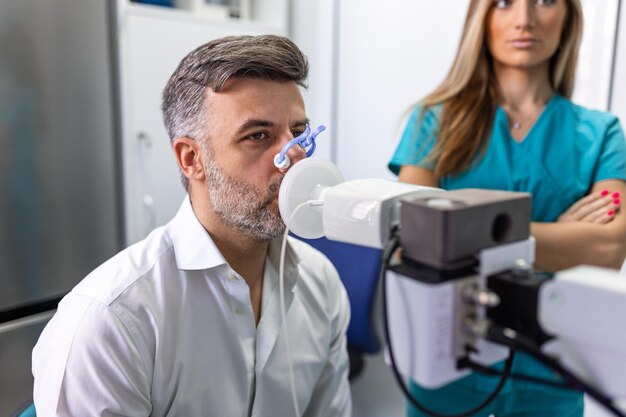 Man die longfunctietest en spirometrie uitvoert met behulp van een spirometer in de medische kliniek Spirometrie van de longen