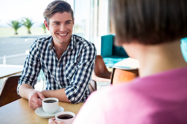 Man die met een vrouw in koffiewinkel spreekt