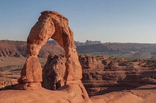 Man die midden in een rotsformatie in het Arches National Park staat