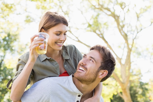 Man die op de rug aan vrouw geeft terwijl het hebben van glas bier