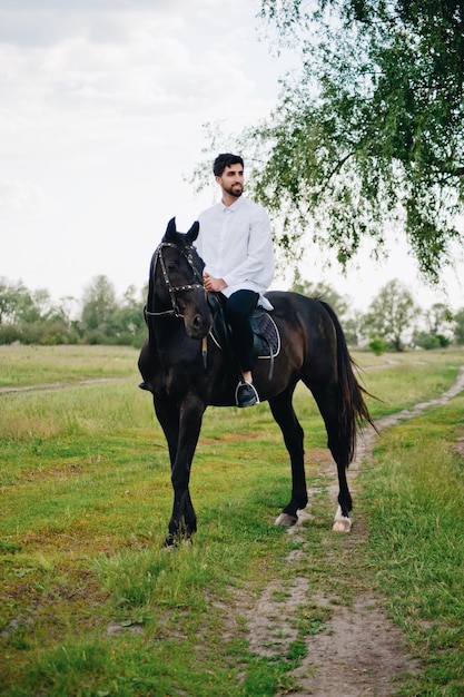 Foto man die op een paard op het veld rijdt