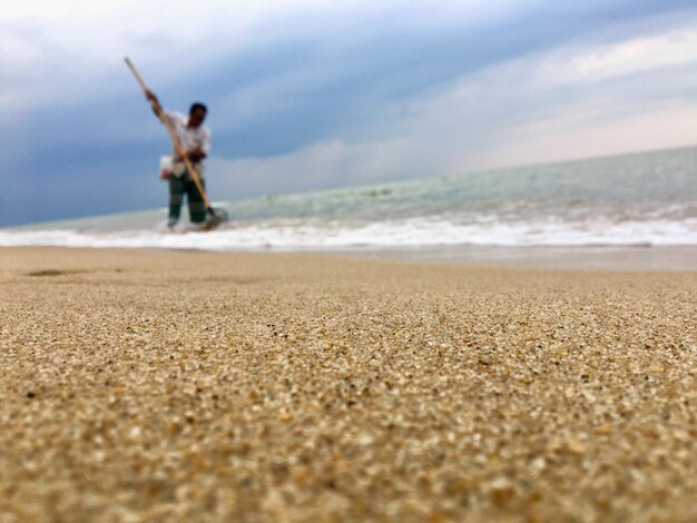 Foto man die op het strand schoonmaakt