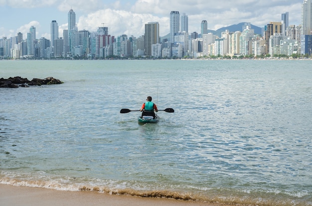 Man die per kajak op het Braziliaanse strand slentert