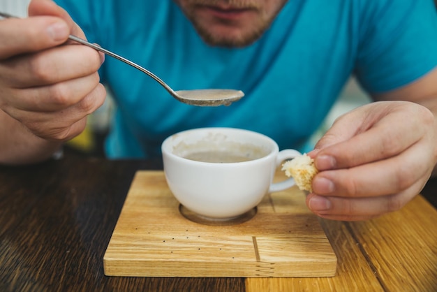 Man die soep eet in café houdt brood in de andere hand