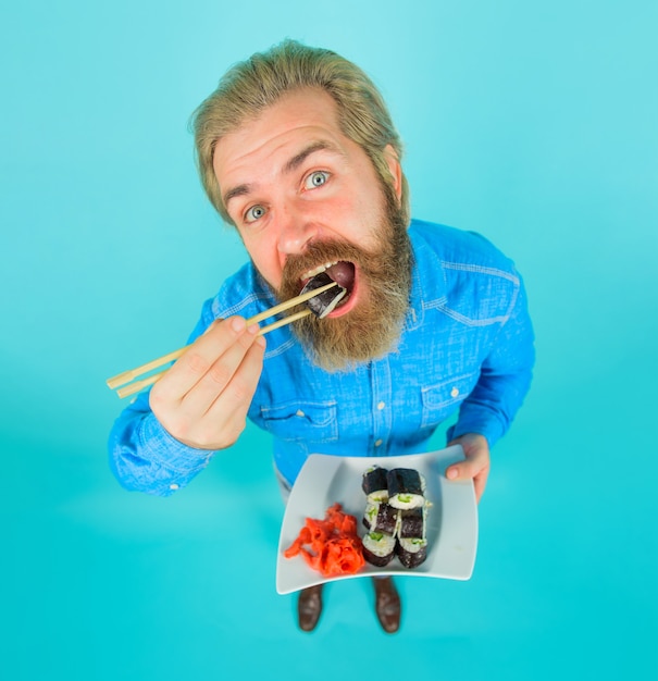 Man die sushi sushi eet man met sushi in eetstokje japan sushi levering japans eten ingelegde gember