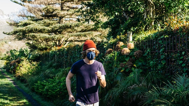 Foto man die tegen bomen jogt.