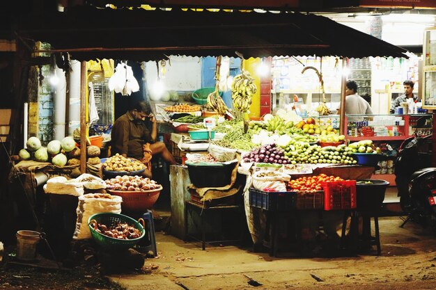 Foto man die verschillende groenten verkoopt op een marktstand