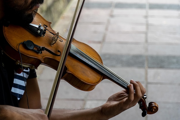 Man die viool speelt Muzikaal thema mannelijke vingers grijpen de snaren en houden de boog vast