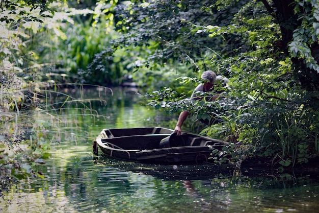 Man die water van een boot bij bomen verzamelt