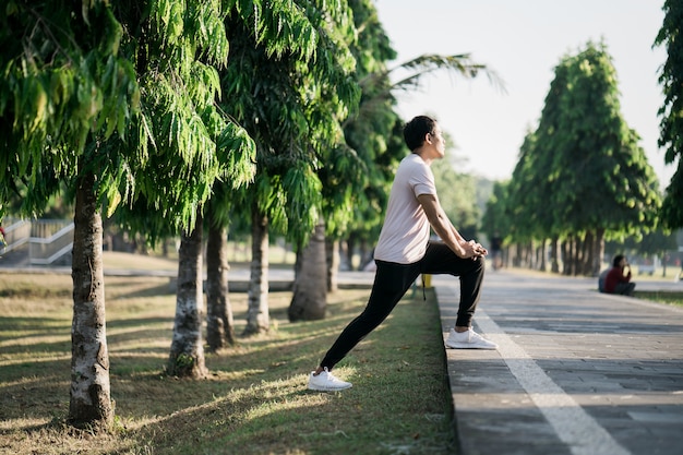 Man die zich uitstrekt in het park fitness concepten