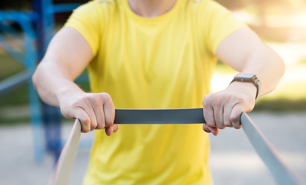 Man die zich uitstrekt met elastisch rubber tijdens straattraining