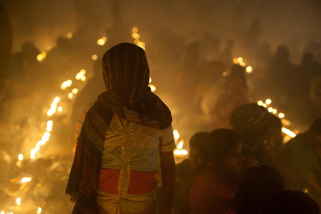 Foto man die zijn gezicht met stof bedekt terwijl hij's nachts bij de menigte staat