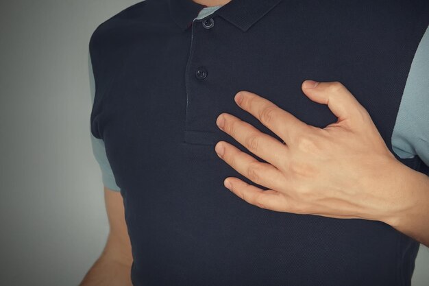Man die zijn handen aanraakt met een hartaanval pijn op de borst met angina pectoris mentale pijn mentaal lijden ervaring emotie zorgen maken