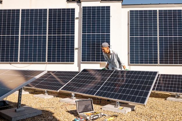 Foto man die zonnepanelen op het dak van zijn huis installeert