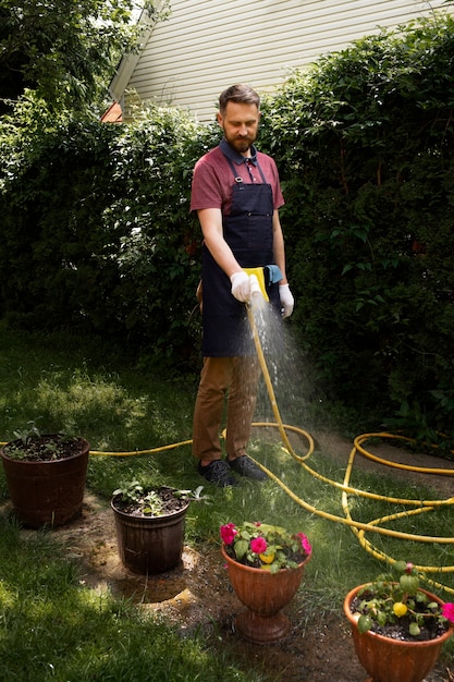 Foto man dienaar zorgt voor de tuin