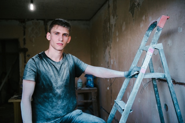 Photo a man in dirty clothes after repair