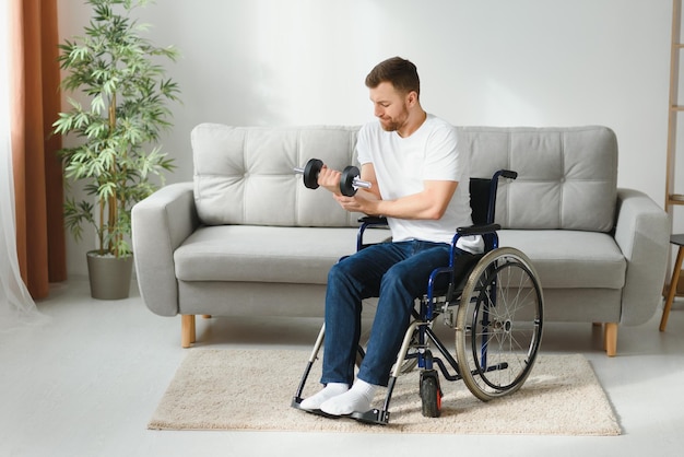 手にダンベルを持った車椅子の障害のある男性のための男性障害者スポーツ手にダンベルを持った男性障害者のアパート健康コンセプトでスポーツをスポッティングする健康的なライフスタイル