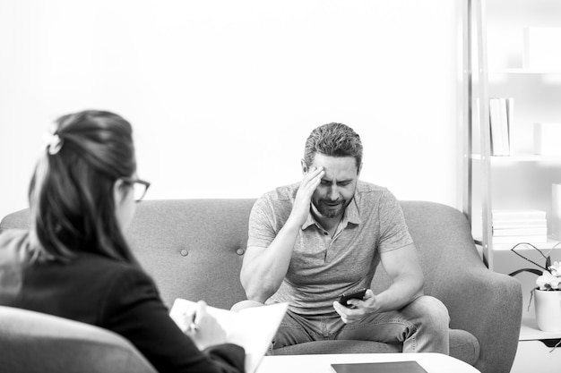 Man discussing his psychological problems with a psychiatrist during a therapy session Social worker counseling parental