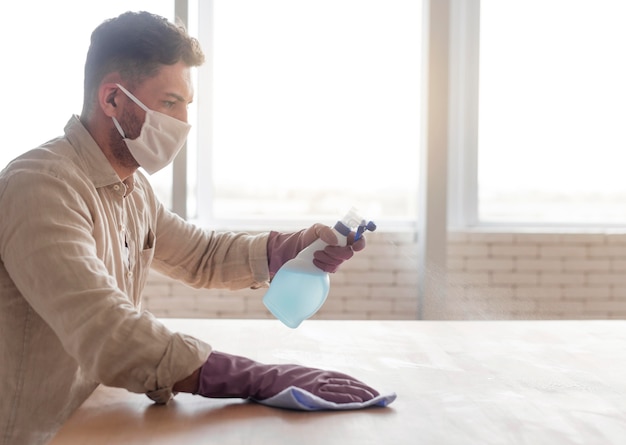 Man disinfecting wooden surface