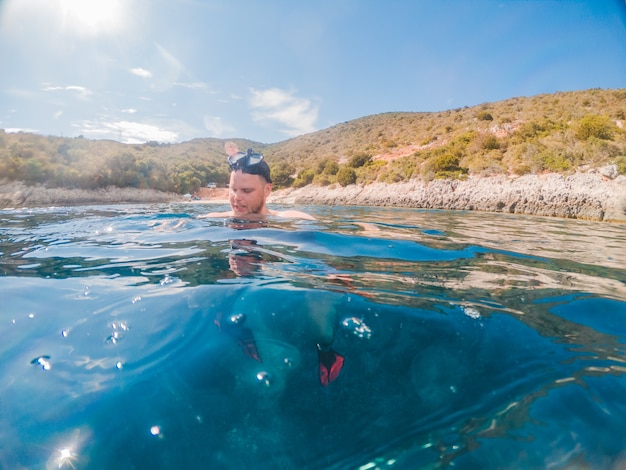 Man in diving mask snorkeling in sea water greece vacation